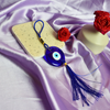 Handcrafted blue Nazar evil eye charm keychain with tassel, featuring traditional Turkish design for protection and good luck.